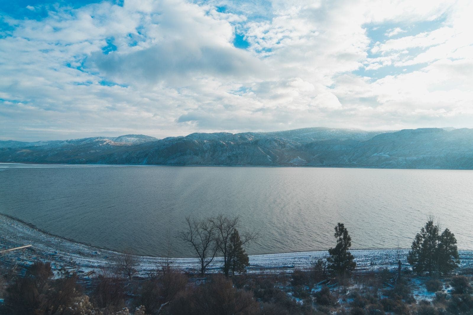 Okanagan Lake and the hills around Kelowna under a cloudy sky